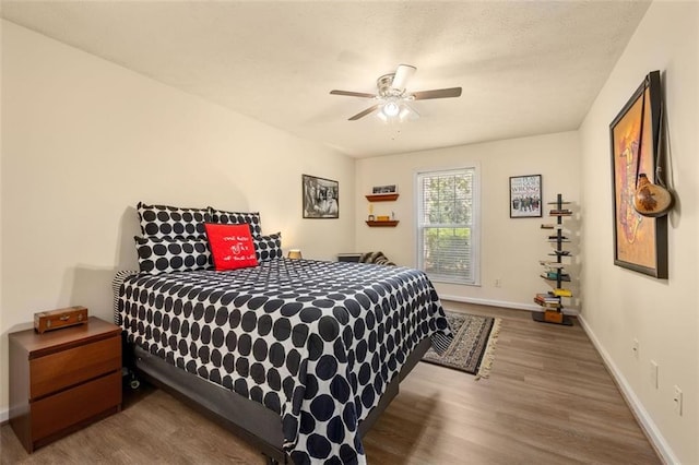 bedroom featuring baseboards, a ceiling fan, and wood finished floors
