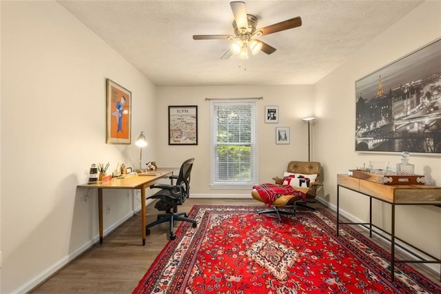 home office with baseboards, ceiling fan, a textured ceiling, and wood finished floors