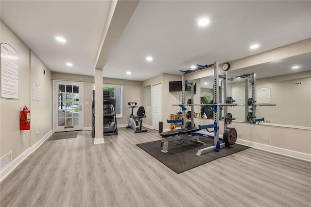 workout area with baseboards and wood finished floors