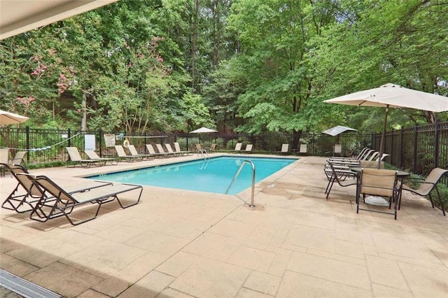 community pool featuring a patio and fence