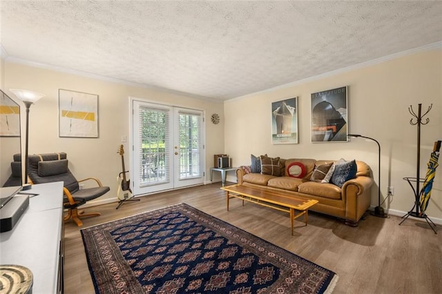 living room featuring crown molding, baseboards, a textured ceiling, and wood finished floors