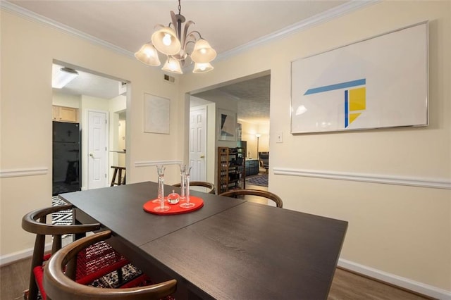 dining room with baseboards, a chandelier, wood finished floors, and visible vents