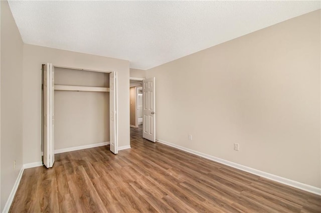 unfurnished bedroom featuring hardwood / wood-style flooring and a closet