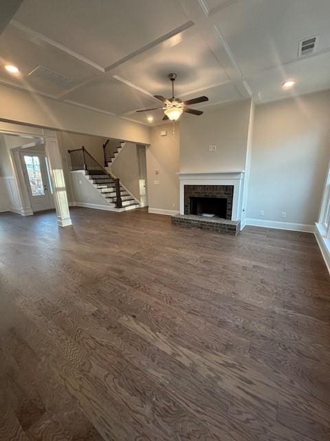 unfurnished living room featuring coffered ceiling, dark wood-style floors, baseboards, a ceiling fan, and a brick fireplace