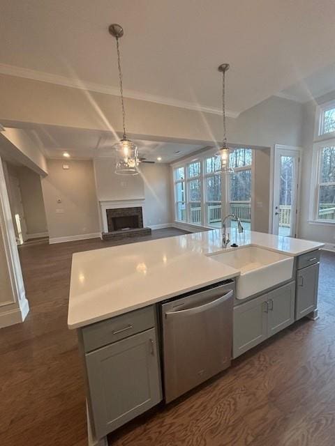 kitchen with dishwasher, a sink, open floor plan, dark wood-style floors, and baseboards