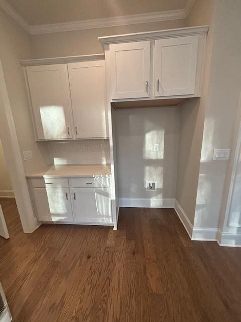 kitchen with light countertops, dark wood finished floors, white cabinets, baseboards, and tasteful backsplash