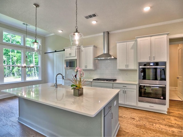 3730 Reserve Overlook Way, Cumming, GA 30041 - kitchen featuring wall chimney exhaust hood, stainless steel double oven, a sink, crown molding, and light wood-type flooring