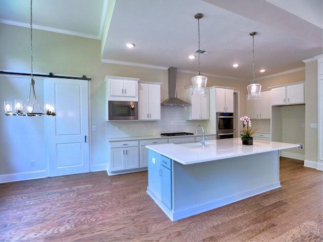 3730 Reserve Overlook Way, Cumming, GA 30041 - kitchen featuring wall chimney exhaust hood, appliances with stainless steel finishes, a sink, white cabinets, and wood finished floors