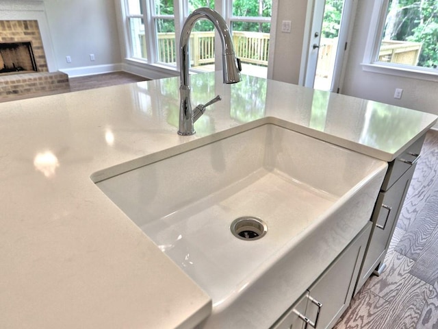 3730 Reserve Overlook Way, Cumming, GA 30041 - detailed view of a sink, a brick fireplace, gray cabinets, and baseboards