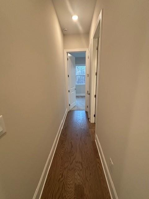 hall featuring dark wood-style floors and baseboards