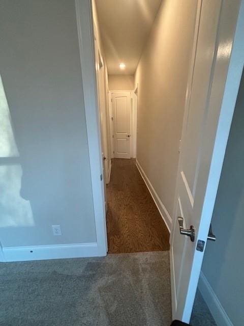 hall featuring carpet and baseboards