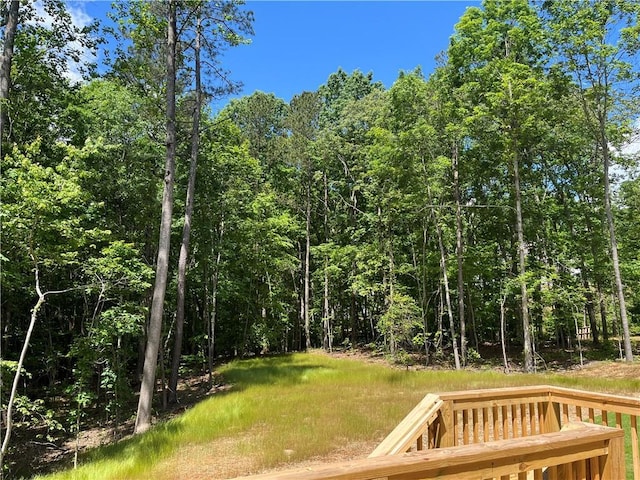 view of yard with a view of trees and a wooden deck