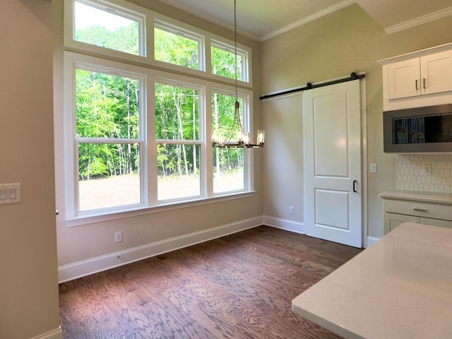 3730 Reserve Overlook Way, Cumming, GA 30041 - kitchen featuring a barn door, plenty of natural light, dark wood-style flooring, crown molding, and light countertops