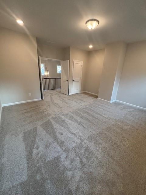 carpeted empty room featuring baseboards