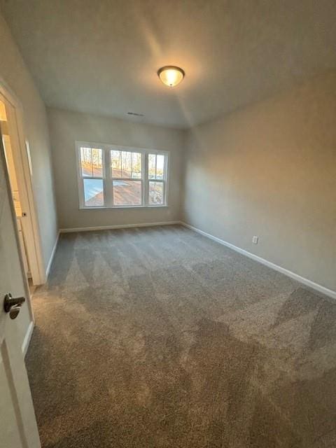 carpeted empty room with baseboards