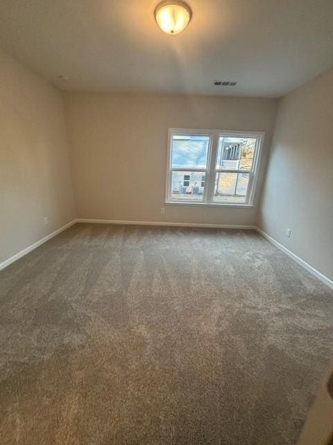 carpeted empty room featuring baseboards