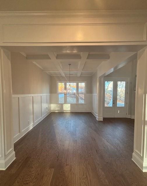 unfurnished room featuring dark wood-style floors, healthy amount of natural light, beam ceiling, french doors, and a wainscoted wall