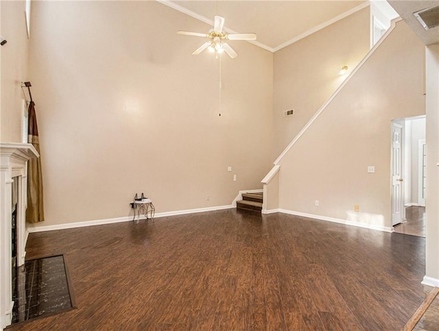 unfurnished living room with ornamental molding, a towering ceiling, dark hardwood / wood-style floors, and ceiling fan