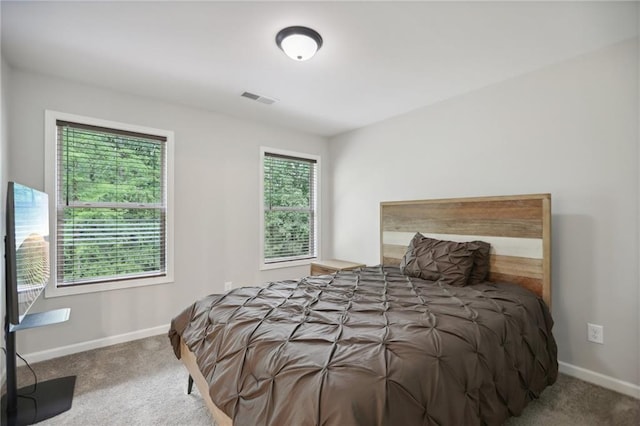 bedroom with carpet floors, visible vents, and baseboards