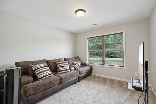 carpeted living area featuring visible vents and baseboards