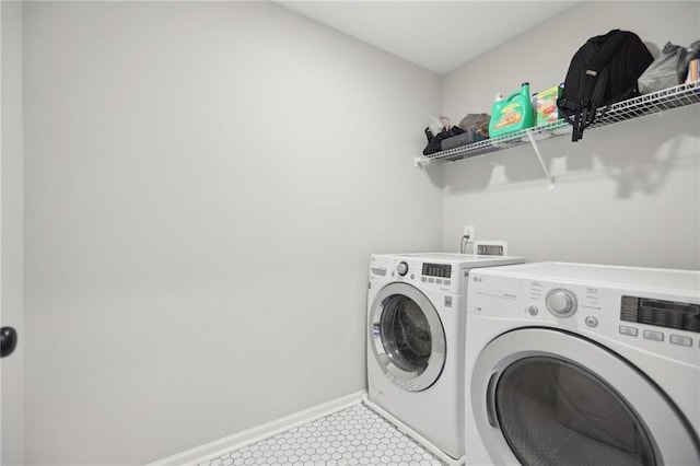 laundry area featuring laundry area, independent washer and dryer, baseboards, and light tile patterned floors