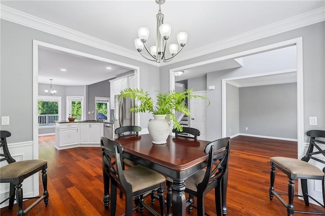 dining space with crown molding, dark wood-style flooring, and a notable chandelier