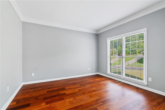 unfurnished room with baseboards, ornamental molding, and dark wood-style floors