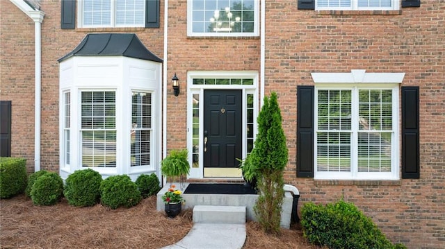 doorway to property with brick siding