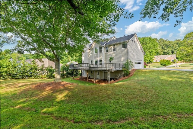 back of property with an attached garage, a lawn, and a wooden deck
