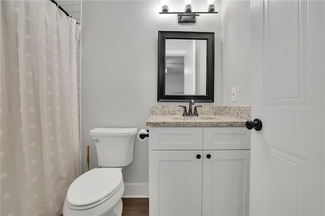 bathroom with a shower with shower curtain, vanity, and toilet