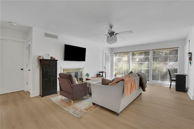 living room with ceiling fan and light hardwood / wood-style floors