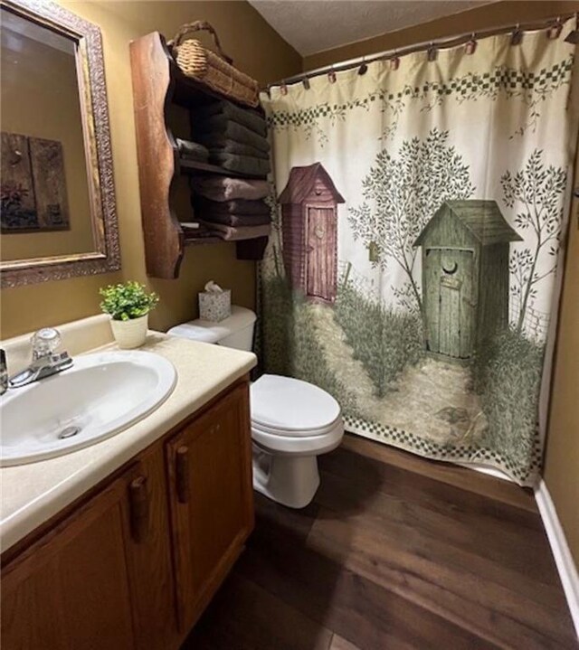 bathroom featuring hardwood / wood-style flooring, vanity, a textured ceiling, curtained shower, and toilet