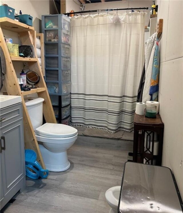 bathroom with a shower with curtain, vanity, toilet, and hardwood / wood-style floors