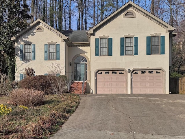 view of front of house featuring aphalt driveway, an attached garage, and stucco siding