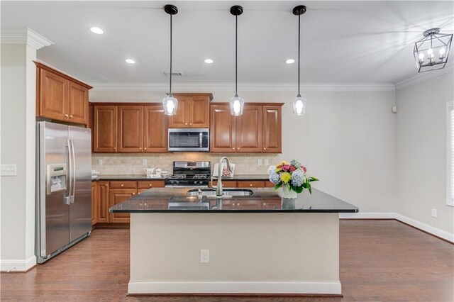 kitchen with appliances with stainless steel finishes, brown cabinetry, a sink, and visible vents