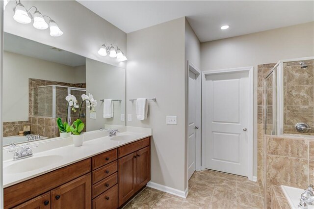 bathroom featuring double vanity, a sink, a shower stall, and a bath