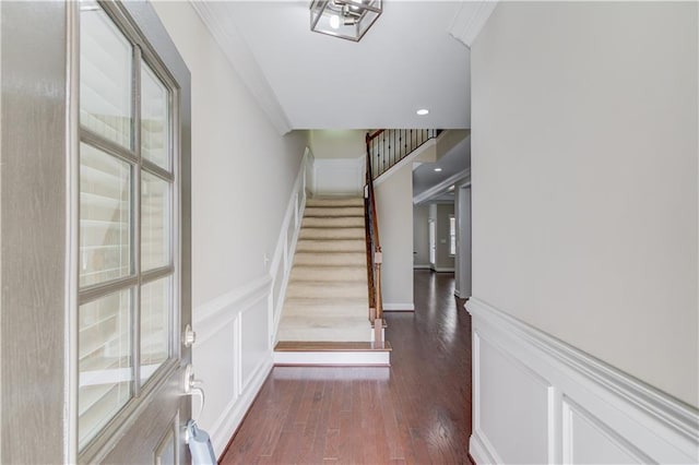 stairs with wainscoting, ornamental molding, wood finished floors, a decorative wall, and recessed lighting