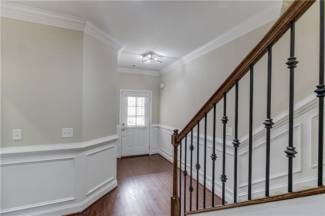 entryway with stairway, ornamental molding, dark wood finished floors, and wainscoting