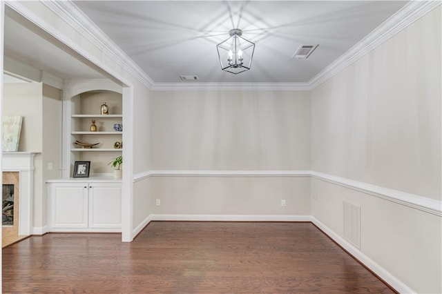 unfurnished dining area with visible vents, wood finished floors, crown molding, built in shelves, and a chandelier