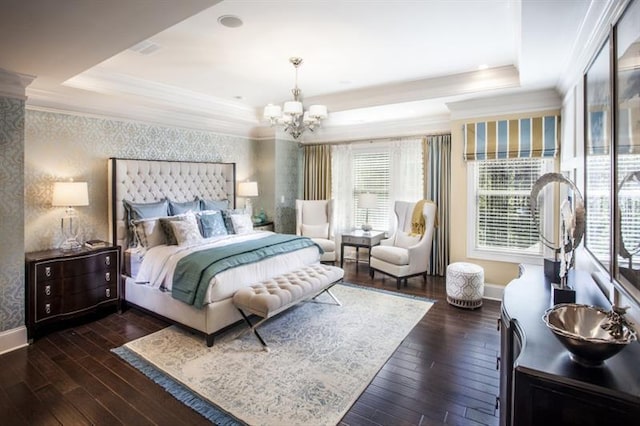 bedroom featuring a tray ceiling, dark wood-type flooring, and a notable chandelier