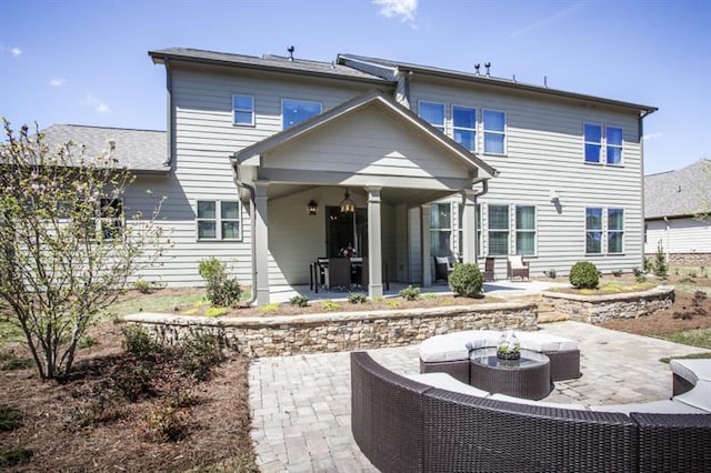 back of property with outdoor lounge area and a patio area