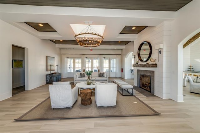 living room with french doors, light hardwood / wood-style floors, and a notable chandelier