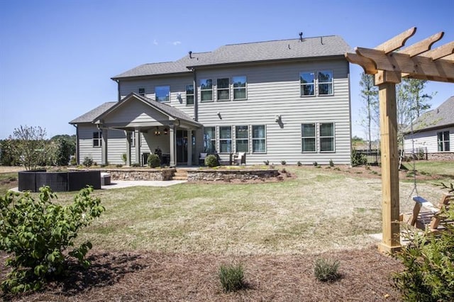 rear view of property featuring a yard, a patio area, and a pergola