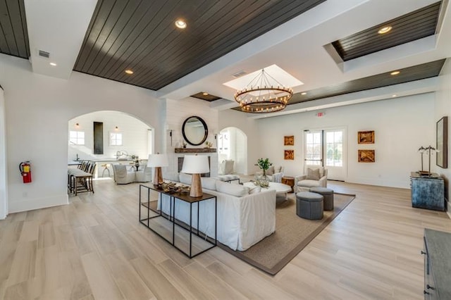 living room with light hardwood / wood-style flooring and a notable chandelier