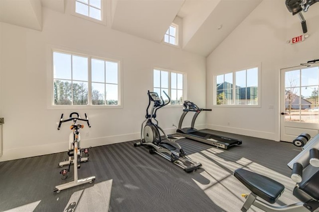 workout room with dark carpet, high vaulted ceiling, and a wealth of natural light