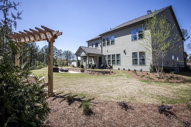 back of property featuring a yard and a pergola