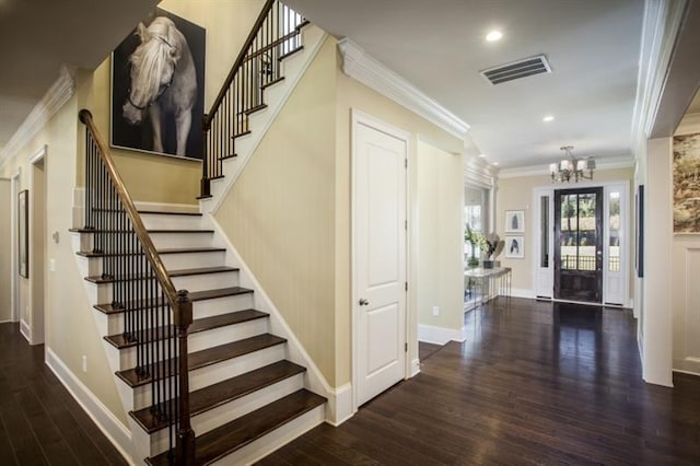 entrance foyer featuring dark hardwood / wood-style flooring, a notable chandelier, and ornamental molding