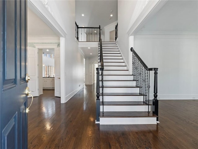 entrance foyer with crown molding and dark hardwood / wood-style floors