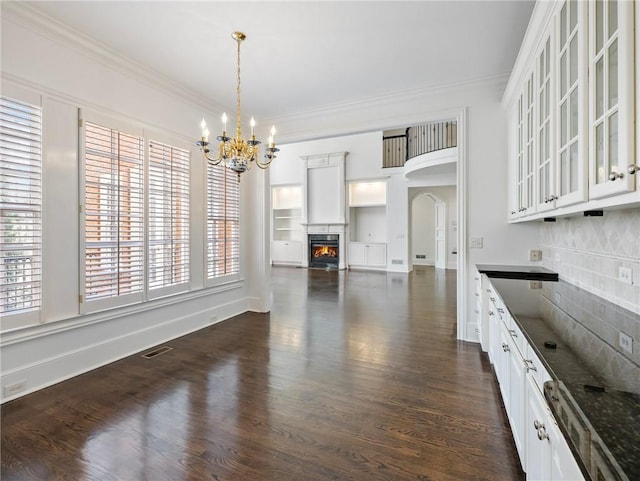 kitchen featuring white cabinetry, tasteful backsplash, decorative light fixtures, ornamental molding, and a notable chandelier