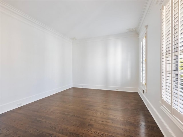 spare room featuring ornamental molding and dark hardwood / wood-style flooring